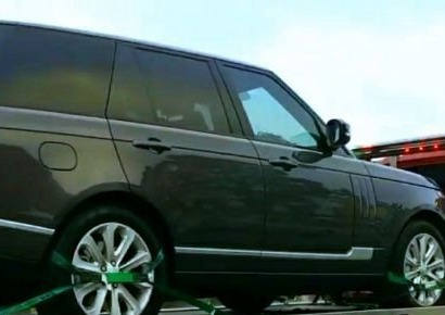 Dark full-size SUV strapped on a flatbed deck