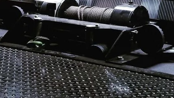 Winch at the head of a diamond-plate flatbed deck